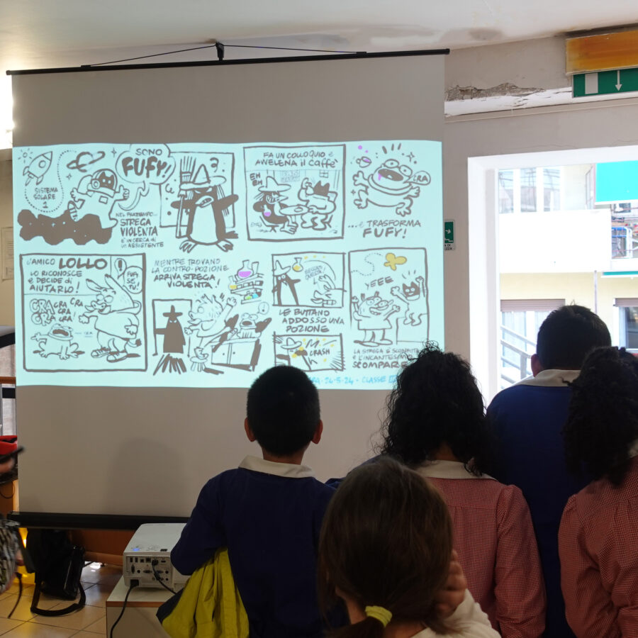 Bambini visti di spalle guardano il telo su cui sono proiettati i disegni delle FreeStory